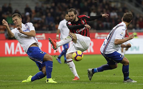 AC Milan's Gonzalo Higuain fires a shot past Sampdoria's Joachim Andersen, left, and Bartosz Bereszynski during the Serie A soccer match between AC Milan and Sampdoria, at the San Siro stadium in Milan, Italy, Sunday, Oct. 28, 2018. | AP