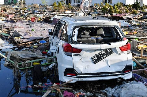 A car washed away by the tsunami is seen among debris in Palu, Indonesia's Central Sulawesi on October 3, 2018, after an earthquake and tsunami hit the area on September 28. Nearly 1,400 people are now known to have died in the quake-tsunami that smashed