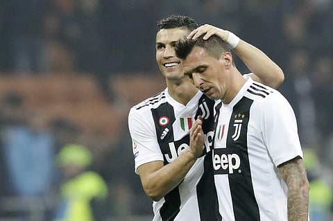 Juventus' Cristiano Ronaldo, left, celebrates with his teammate Juventus' Mario Mandzukic at the end of a Serie A soccer match between AC Milan and Juventus, at Milan's San Siro stadium. (Photo | AP)