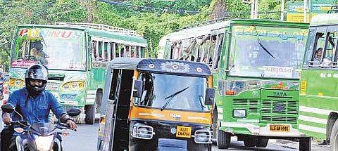 A private bus trying to squeeze in between two others, flouting lane traffic rules