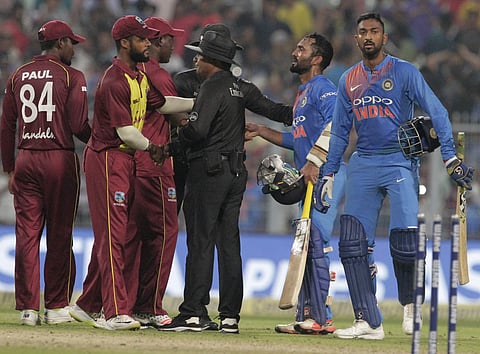 India's Krunal Pandya, right, and teammate Dinesh Karthik, second right, leave the field after their win over West Indies in the first Twenty20 in Kolkata. | AP