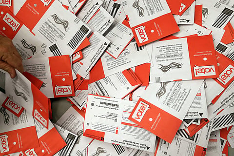 Election workers begin to sort a new batch of ballots collected earlier in the day from drop boxes at the King County Elections office Monday. (Photo| AP)