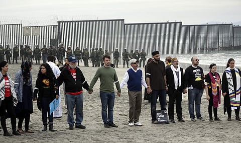 People hold hands in prayer during a protest near the border with Tijuana, Mexico, Monday, Dec. 10, 2018, in San Diego. (Photo | AP)