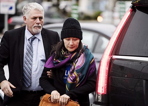 Huawei chief financial officer Meng Wanzhou arrives at a parole office with a security guard in Vancouver, British Columbia, Wednesday, Dec. 12, 2018. | AP