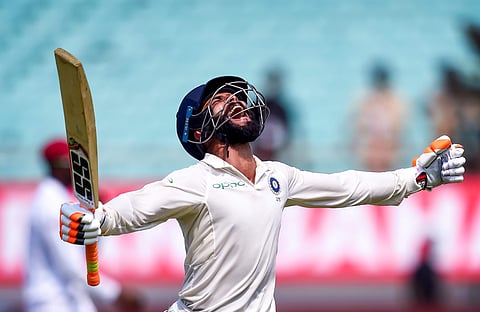 Indian batsman Ravindra Jadeja celebrates his century during the first test cricket match played between India and West Indies in Rajkot.