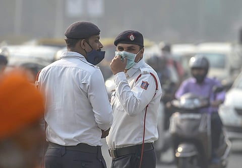 Traffic policemen wear masks to protect themselves as air quality deteriorates in New Delhi. (File Photo|PTI)