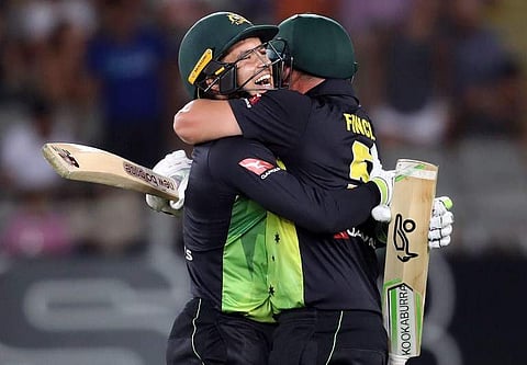 Australia's Alex Carey (L) and Aaron Finch (R) celebrate the win during the Twenty20 Tri Series international cricket match between New Zealand and Australia at Eden Park in Auckland. | AFP