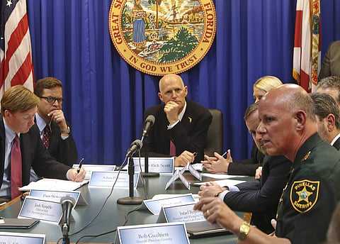Pinellas Sheriff Bob Gualtieri, right, responds to a question from Florida Gov. Rick Scott, back, on gun violence during a meeting at Florida's Capitol, Tallahassee. At left is State Agriculture Commissioner Adam Putnam and Lt. Gov. Carlos Lopez-Cantera.