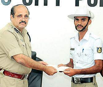 Police Commissioner T R Suresh presents cash award to Revanasiddappa