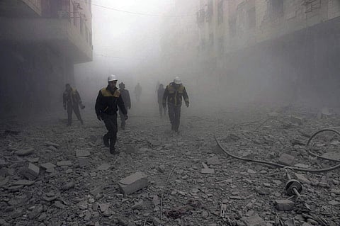 This photo provided by the Syrian Civil Defense group known as the White Helmets, shows civil defense workers searching for survivors after airstrikes hit a rebel-held suburb near Damascus, Syria, Monday, Feb. 5, 2018. The Syrian Observatory for Human Rig