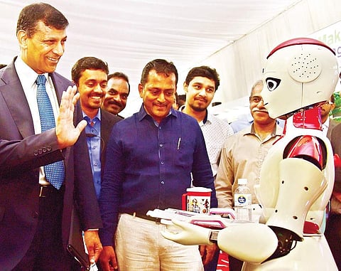 Former RBI Governor Raghuram Rajan is surprised as a robot welcomes him to the Maker Village stall at the #Future summit in Kochi on Friday | Albin Mathew