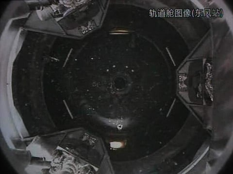 A photo of the giant screen at the Jiuquan space center shows the Tiangong-1 module being filmed from the Shenzhou-9 spacecraft before the automatic docking. (File | AFP)