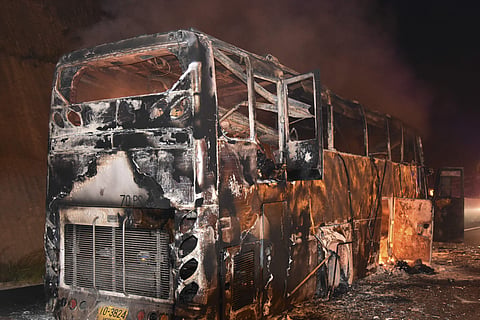 A burnt double-decker bus is seen in Tak province, Thailand, Friday, March 30, 2018. | AP