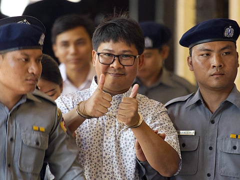 Reuters journalist Wa Lone, center, thumbs up as he is escorted by police upon arrival at the court for trial in Yangon, Myanmar Friday, April 20, 2018. | AP