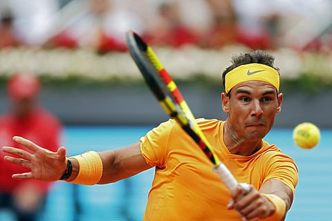 Rafael Nadal from Spain hits a backhand return to Gael Monfils from France during a Madrid Open tennis tournament match in Madrid. (AP)