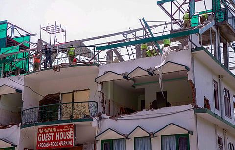 Demolition of unauthorised construction under progress at Kasauli in Solan district on Thursday. | PTI