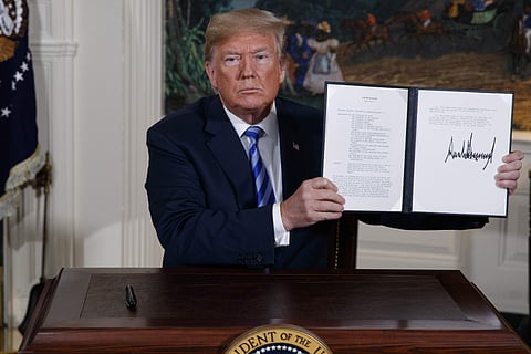 President Donald Trump shows a signed Presidential Memorandum after delivering a statement on the Iran nuclear deal from the Diplomatic Reception Room of the White House. (Photo | AP)