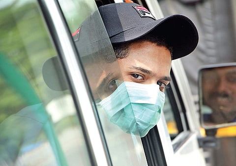 In the wake of the Nipah virus outbreak, a car passenger sports a protective mask. | T P Sooraj