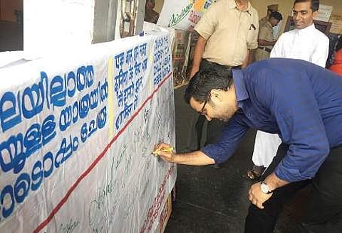 Ernakulam South Railway Station director Harikrishnan signing the signature board placed at the station