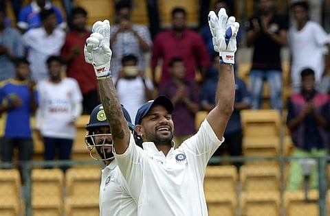 India's Murali Vijay(L) watches as Shikhar Dhawan celebrates scoring a century during the one-off cricket test match against Afghanistan. (EPS | Vinodkumar. T)
