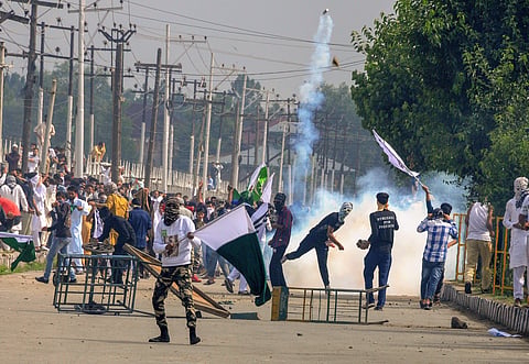 Protestors throw an exploded tear gas shell at police and CRPF personnel in retaliation during a clash which erupted after youth staged a protest march soon after Eid-ul-Fitr prayers in Srinagar on Saturday June 16 2018. | PTI