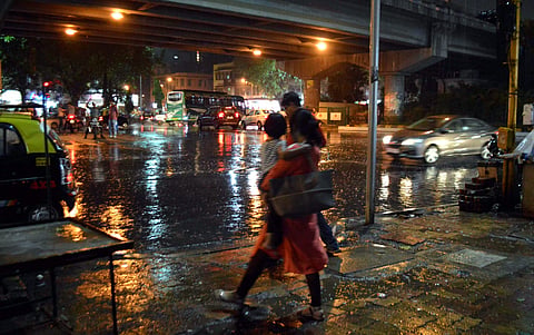 A woman walks during rains in Mumbai on Saturday. (PTI)
