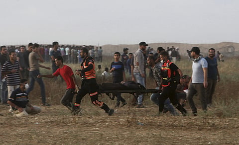 Palestinian medics and protesters evacuate a wounded woman near the Gaza Strip's border with Israel, during a protest east of Khan Younis. | AP