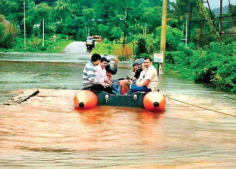 People take a boat on Bhagamandala Road; the Karike-Bhagamandala road that was blocked by an uprooted tree