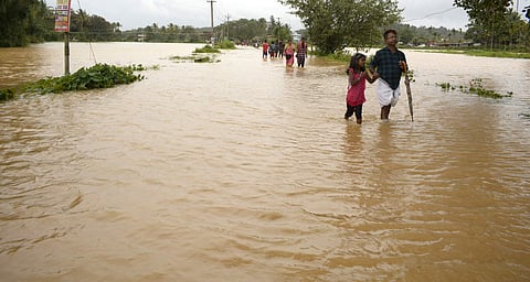 Kerala: People walking through the flooded water as vehicles stopped service through the road in the heavy rain at Valliyooorkkavu in Wayanad. (Photo| ENS/Manu R Mavelil)