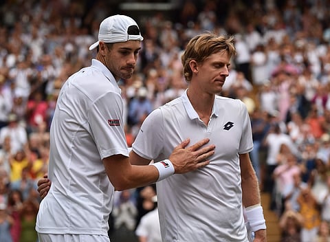Kevin Anderson of South Africa, right, meets John Isner of the US on the court after defeating him in their men's singles semifinal match at the Wimbledon Tennis Championships, in London, Friday July 13, 2018. | AP