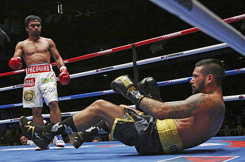 Lucas Matthysse, left, of Argentina falls after receiving a punch by Manny Pacquiao of the Philippines during their WBA World welterweight title bout in Kuala Lumpur. | AP