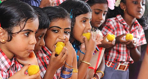 Tiny tots who entered the world of letters on Wednesday relish sweets in Thiruvananthapuram. (File | EPS)