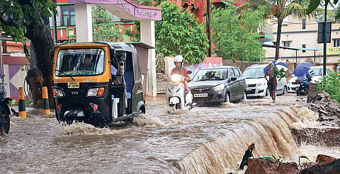 A man clearing water from his house in Jaydurga Nagar