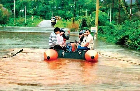 People take a boat on Bhagamandala Road; the Karike-Bhagamandala road that was blocked by an uprooted tree