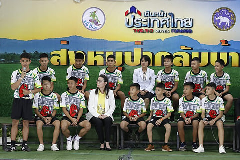 Coach' Ake' Ekkapol Janthawong, left, speaks on behalf of the 12 boys and himself and their cave rescue during a press conference discussing their ordeal in Chiang Rai. (Photo | AP)