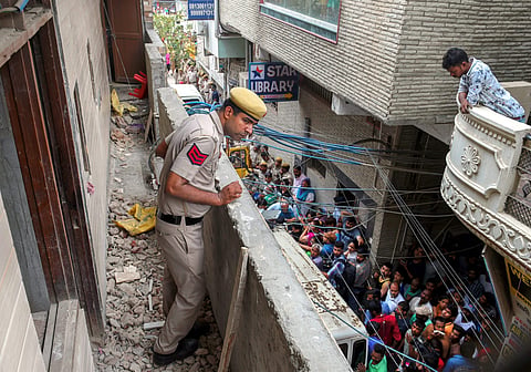 A police man stands in the balcony of the house where 11 members of a family- four men three women and four girls- were found hanging from an iron grill in Burari area of New Delhi on Sunday July 1 2018. | PTI