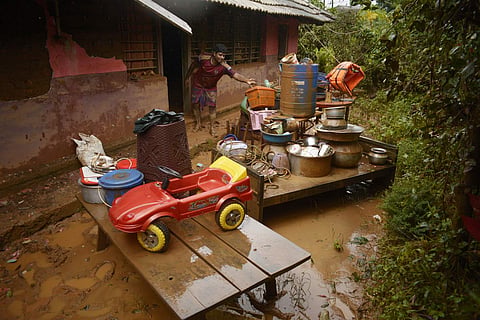 A resident retrieving the household items after the flood water entered his house in Wayanad. (Photo | Manu R Mavelil/ EPS)