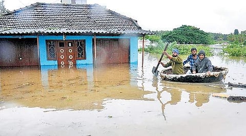 Two men being moved to safer ground by a coracle on Graveyard Road in Koppa of Kodagu district on Friday | Udayashankar S