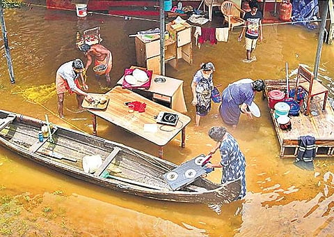 Residents of Eloor, who got back to their houses from camps after water receded, clean utensils as they strive to put life back on track | Albin Mathew