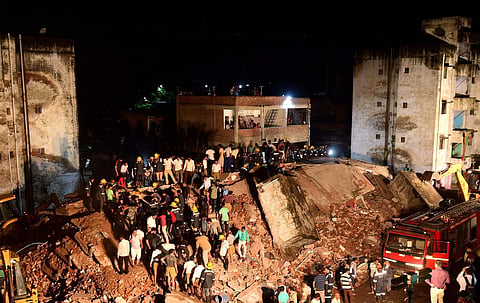 Fire fighters and people try to clear debris of a four-storey government building collapsed in Ahmedabad on Sunday August 26 2018. | PTI