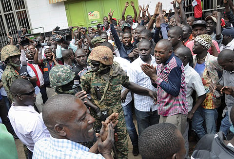 Supporters of Ugandan pop star-turned-lawmaker Bobi Wine, whose real name is Kyagulanyi Ssentamu, plead with Ugandan army soldiers that they should allow Wine to leave the country for treatment, during protests in Kampala, Uganda, August 31, 2018. (Photo