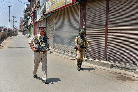 Security personnel patrol a street during a two-day strike called by the separatist leaders against the petitions in the Supreme court challenging the validity of Article 35A in Srinagar on Sunday August 05 2018. | PTI