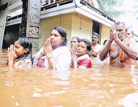 Devotees having a dip in the flooded water marking the arattu of Thanikkudam Bhagavathi temple in Thrissur on Wednesday | Express