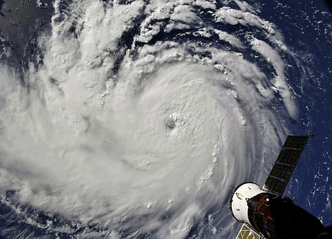 This enhanced satellite image provided by NOAA shows Hurricane Florence, third from right, in the Atlantic Ocean on Sunday, Sept. 9, 2018. At right is Tropical Storm Helene, and second from right is Tropical Storm Isaac. (NOAA via AP)