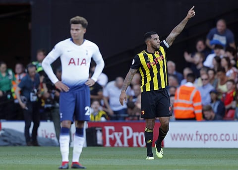 Watford's Troy Deeney celebrates after scoring his side's first goal to Tottenham's Dele Alli, left, next during the English Premier League soccer match at Vicarage Road stadium. | AP