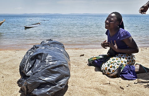 A woman cries beside the body of her sister, a victim of the MV Nyerere passenger ferry, as she awaits transportation for burial on Ukara Island, Tanzania Saturday, Sept. 22, 2018. The death toll soared past 200 on Saturday while officials said a survivor