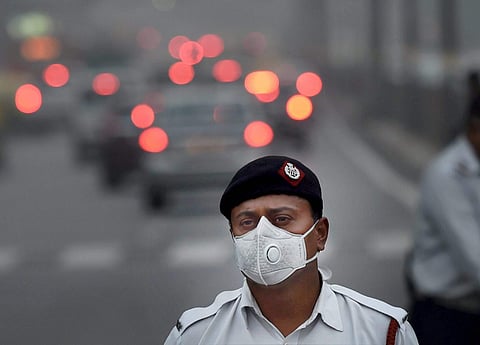 A traffic policeman wears an anti-pollution mask to protect himself from growing level of air pollution in New Delhi. (File | PTI)