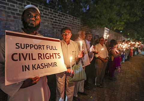 Social activists hold a placard and candles during a silent protest against government on Kashmir issue in Ahmedabad Thursday Oct. 17 2019. | (Photo | PTI)
