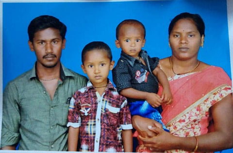 Sujith Wilson, seen in his mother's hands, with his elder brother and father.
