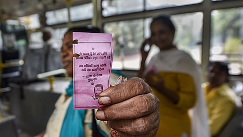 A woman shows the 'pink ticket' during her ride on a DTC Bus in New Delhi. (Photo|PTI)